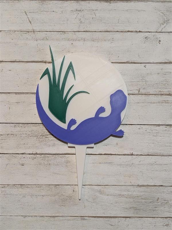 Custom circular golf tee sign featuring a purple shoreline and green landscape design