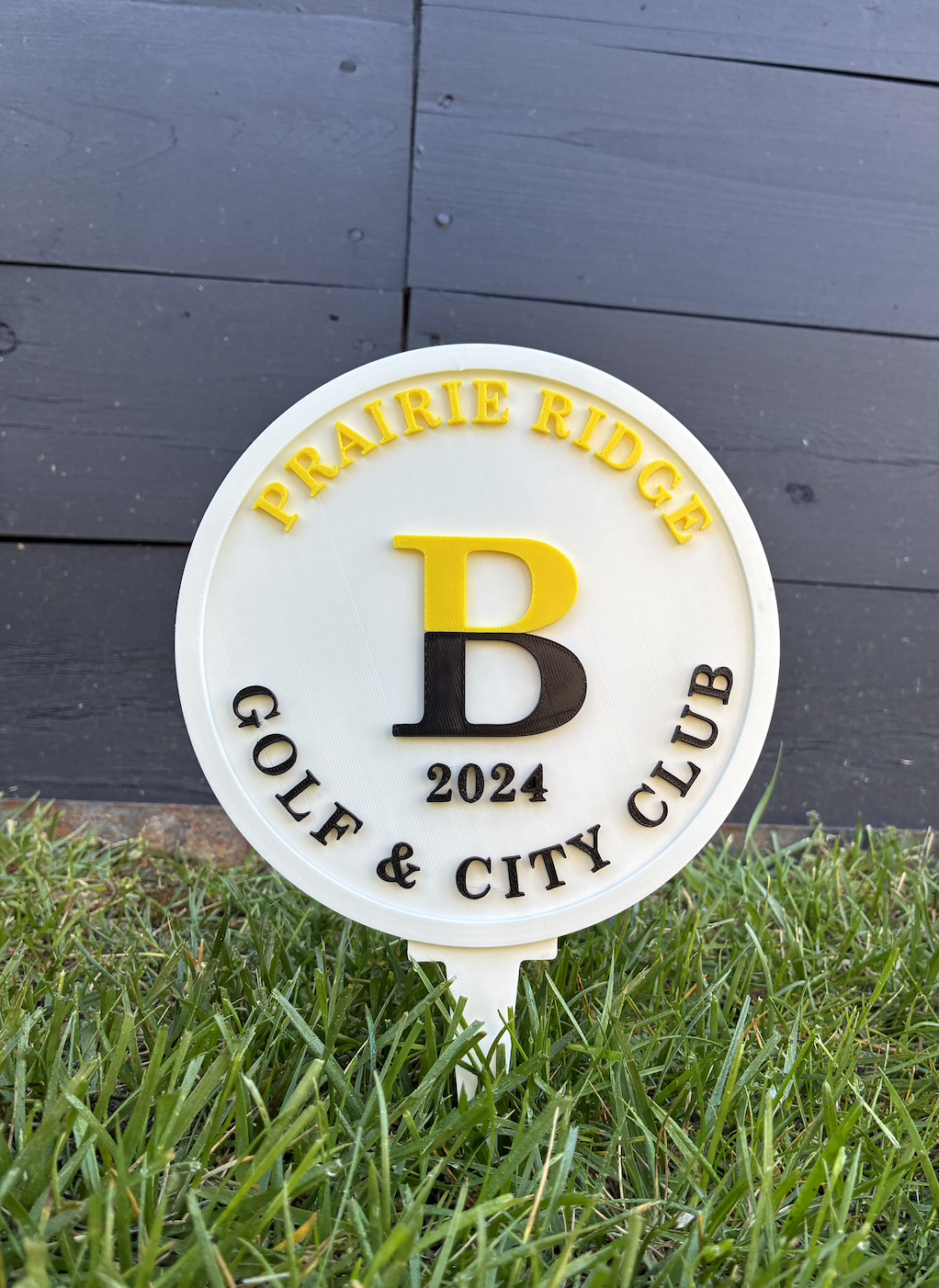White Prairie Ridge Golf and City Club sign with yellow and black lettering